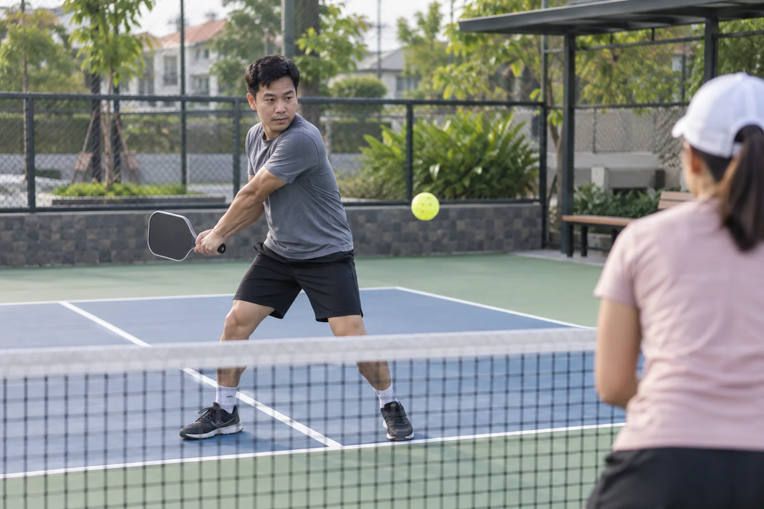 Người mới thực hiện cú đánh trái tay hai tay từ cuối sân pickleball