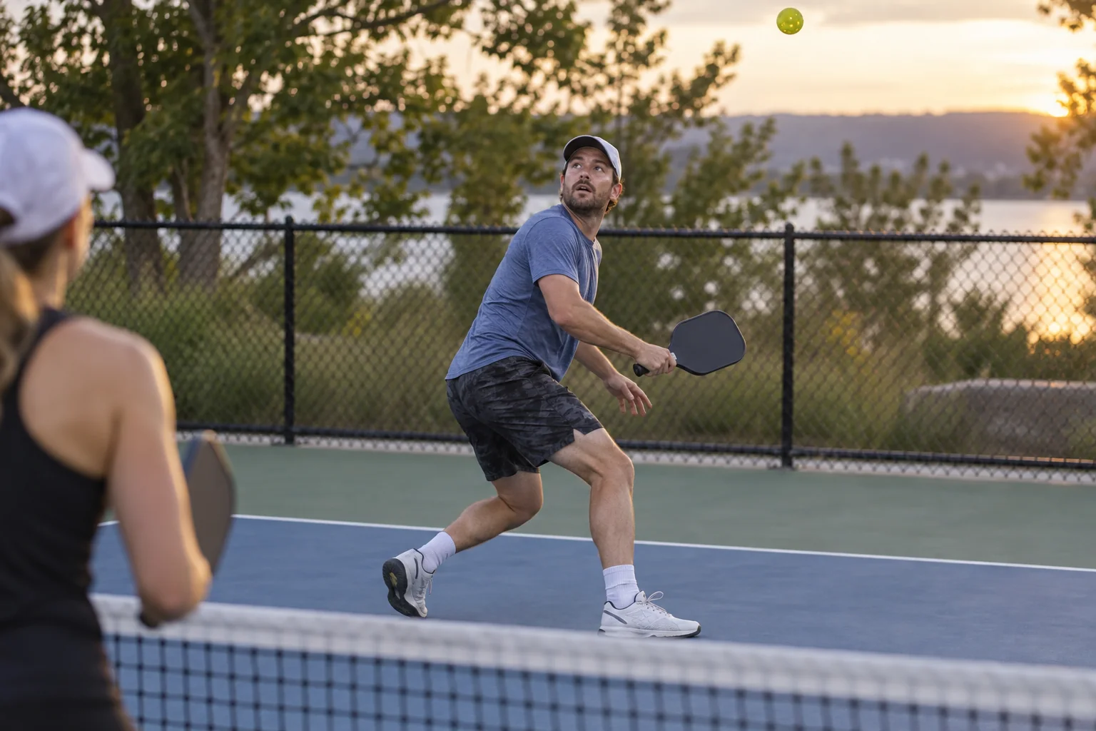 Jogador usa o passo de abertura para acompanhar um lob no pickleball