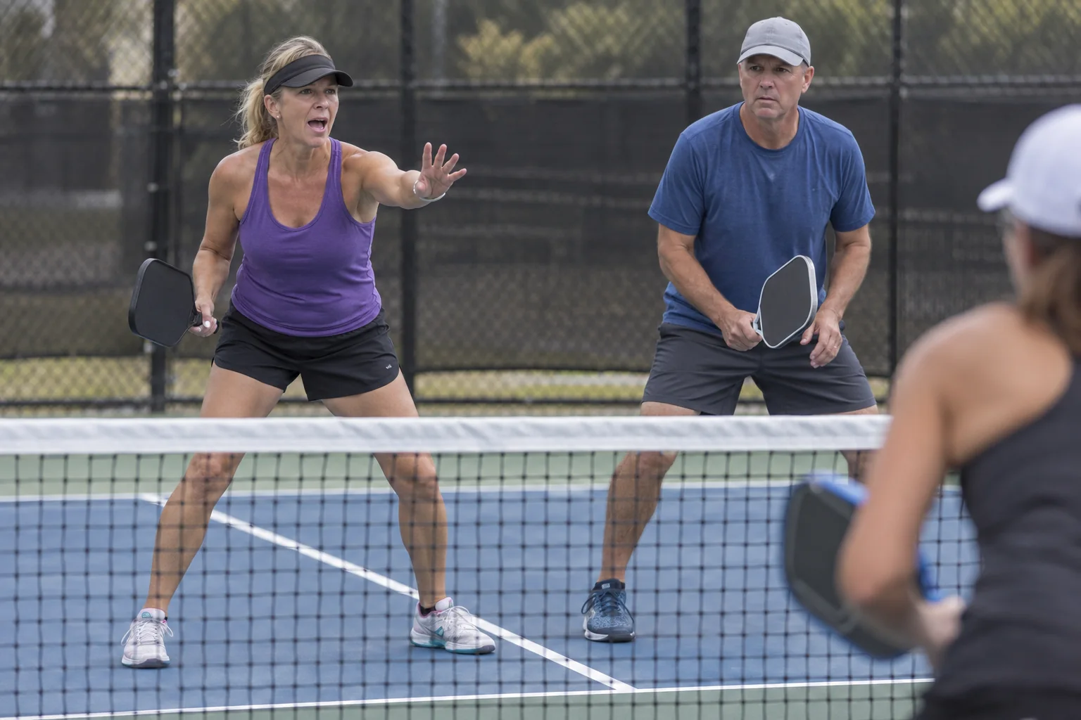 Doubles partners communicating over a middle ball at the kitchen line